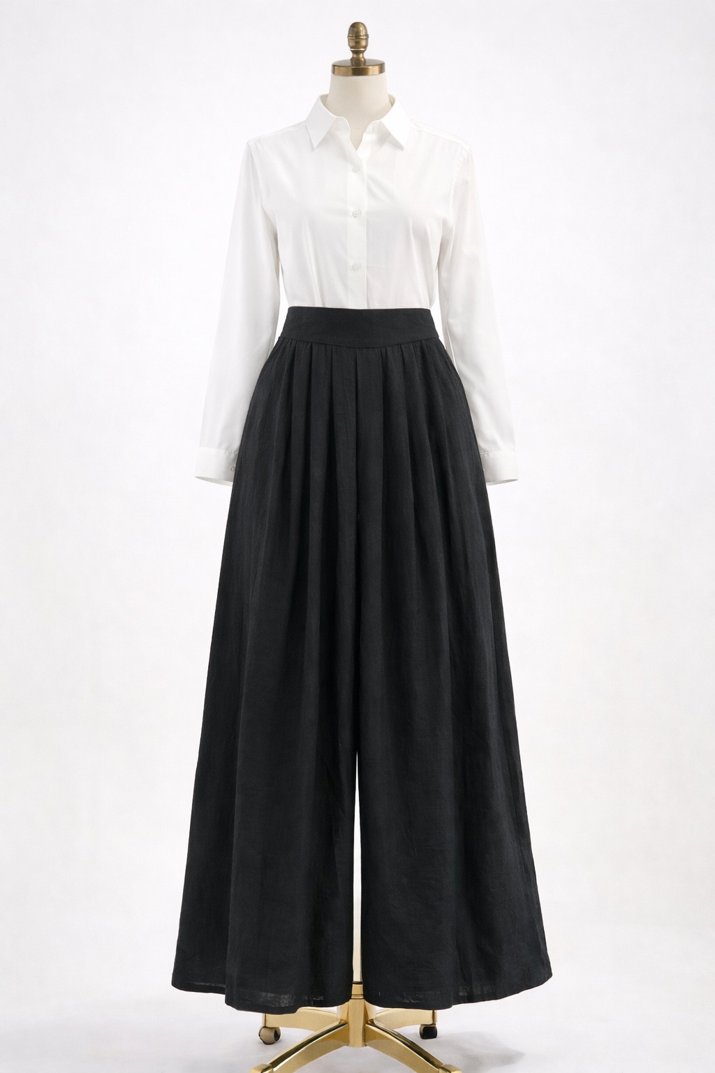 Mannequin wearing a white shirt and black wide-leg pants on a white background