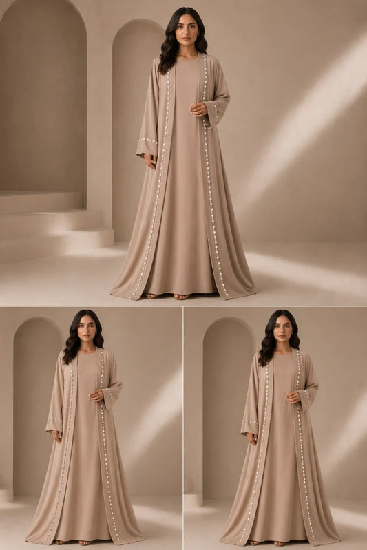 Woman wearing a beige dress with white embellishments in a neutral setting
