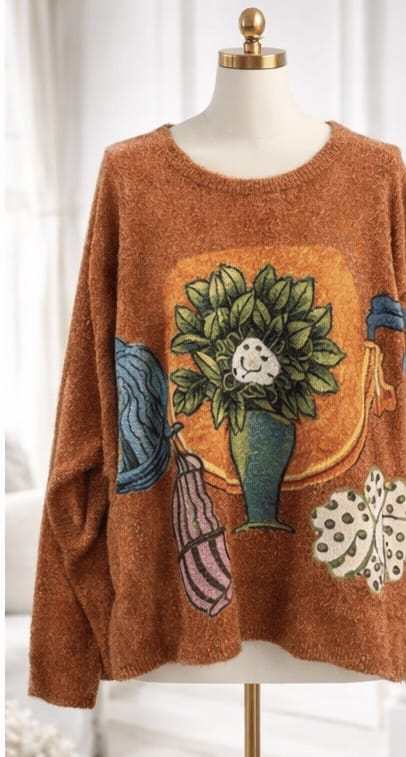 Brown sweater with floral design on a mannequin against a white background