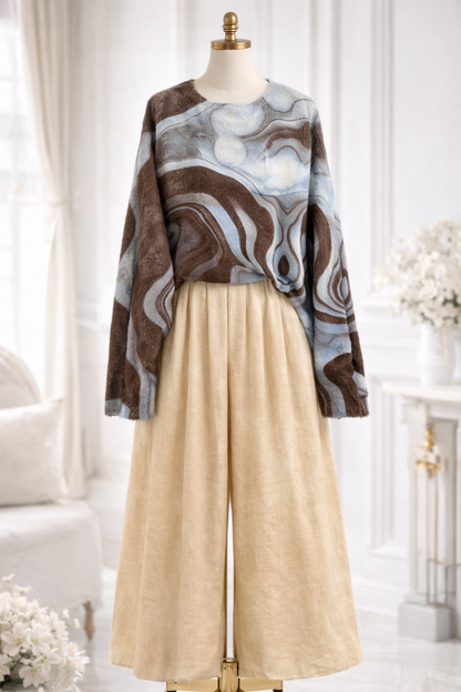 Mannequin wearing a patterned sweater and beige pants in a bright room.