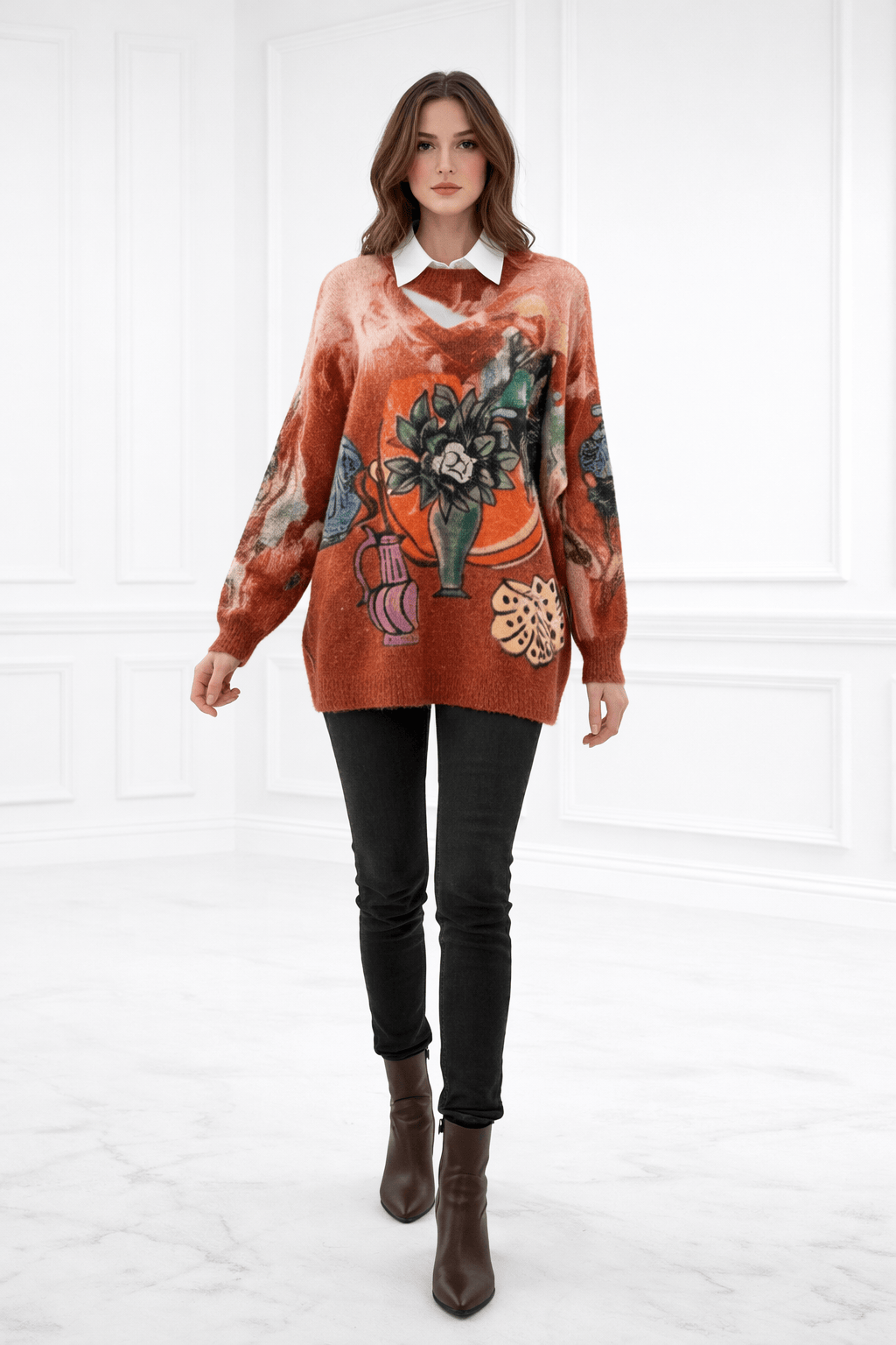 Woman wearing a patterned orange sweater with black pants on a white background