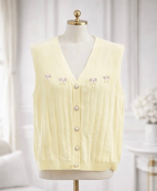 Light yellow cardigan vest on a mannequin against a white background