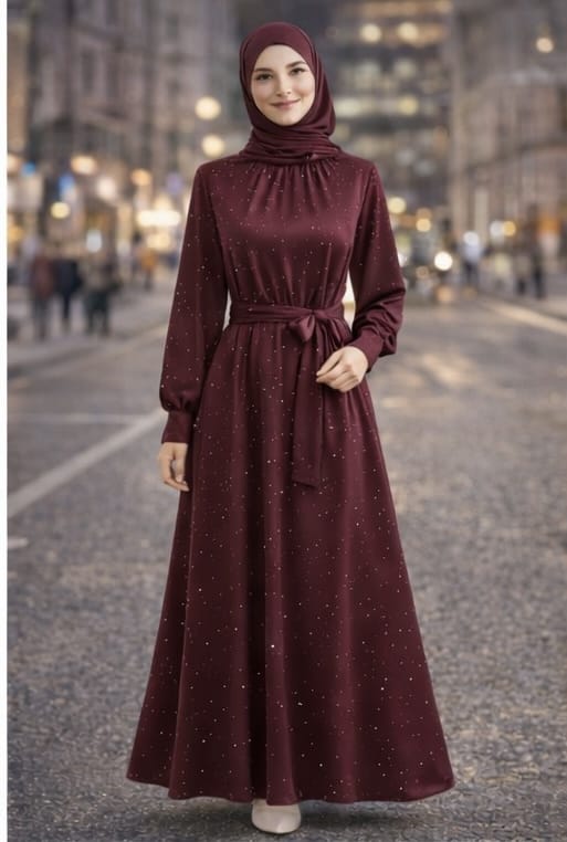 Woman wearing a burgundy dress with a hood on a city street.