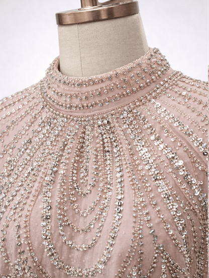 Two mannequins wearing pink beaded tops on a white background