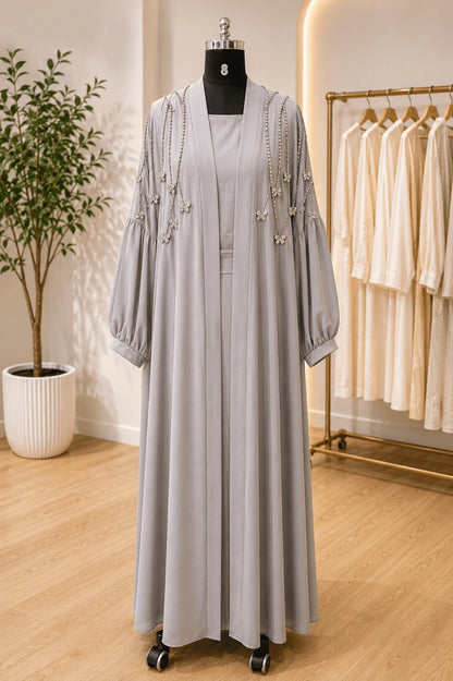 Gray dress with embellishments on a mannequin in a store setting.