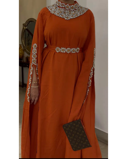 Orange dress with intricate beadwork on a plain background
