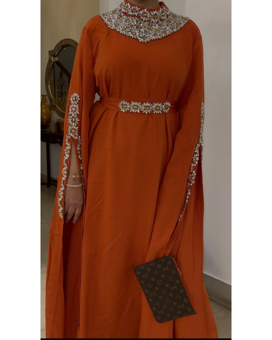 Orange dress with intricate beadwork on a plain background