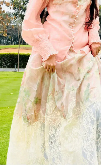Person wearing a light pink floral dress with a blurred outdoor background