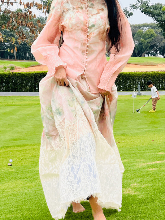 Person in a floral dress on a golf course with another person in the background.